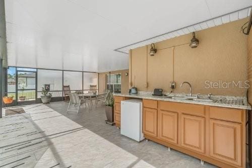 kitchen featuring fridge, light countertops, and a sink