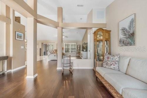 interior space with lofted ceiling, dark wood finished floors, and baseboards