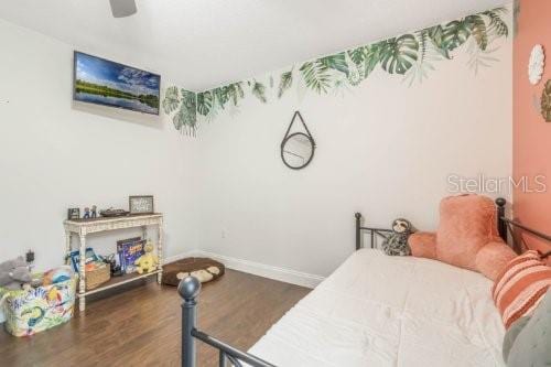 bedroom featuring dark wood finished floors, baseboards, and ceiling fan