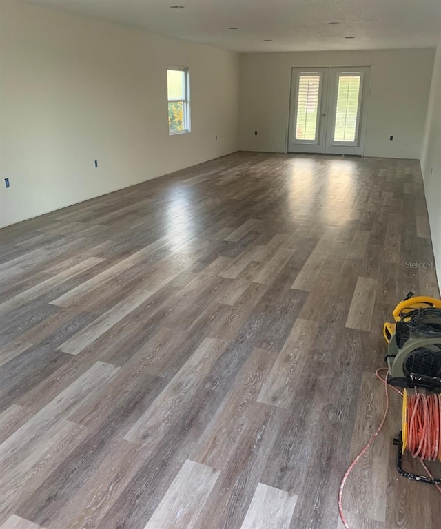 empty room with a healthy amount of sunlight and wood finished floors