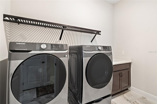 laundry area with cabinets and washer and clothes dryer