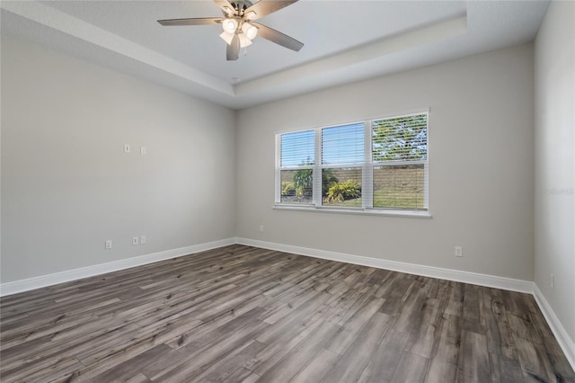 spare room featuring hardwood / wood-style floors, ceiling fan, and a tray ceiling