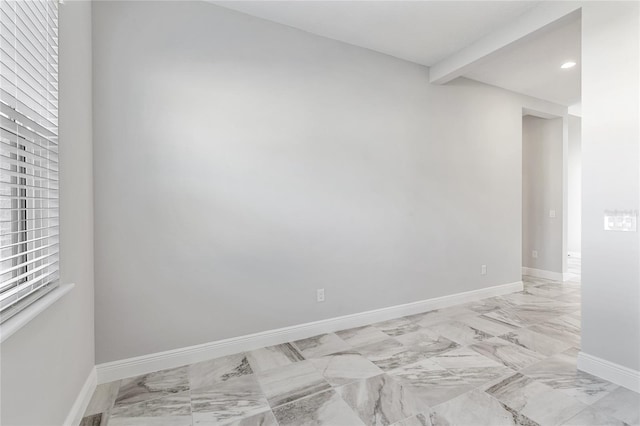 empty room featuring beam ceiling