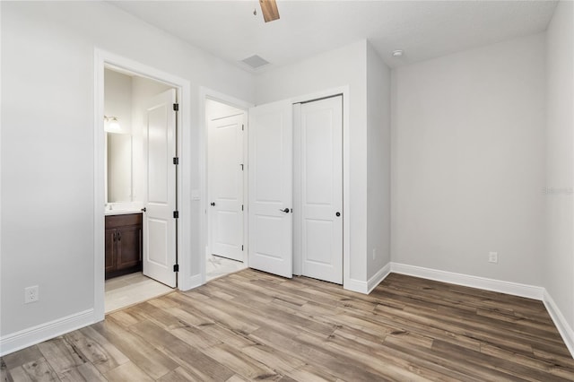 unfurnished bedroom featuring ceiling fan, light hardwood / wood-style floors, connected bathroom, and a closet