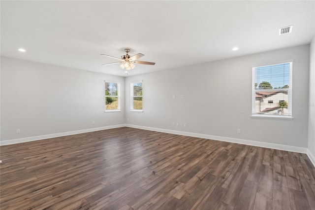 unfurnished room featuring ceiling fan, dark hardwood / wood-style flooring, and a wealth of natural light