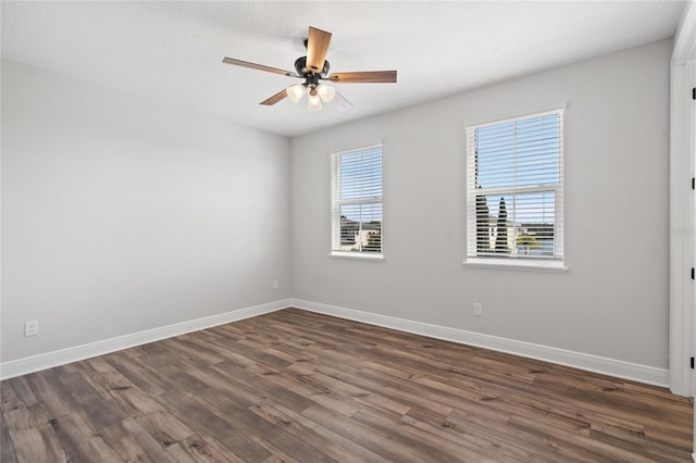 empty room with a textured ceiling, dark hardwood / wood-style flooring, and ceiling fan