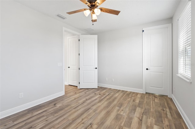 unfurnished bedroom with ceiling fan and light wood-type flooring