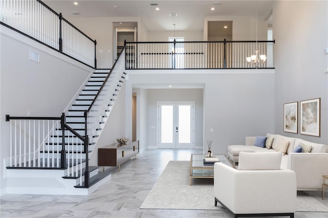 living room with an inviting chandelier, a high ceiling, and french doors