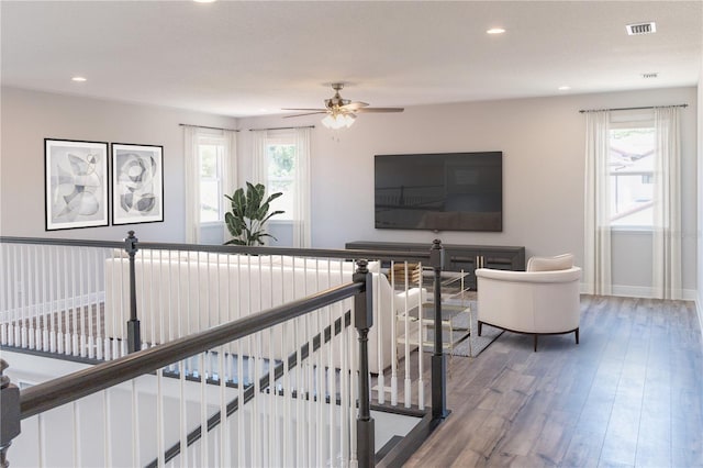 living room with wood-type flooring, a wealth of natural light, and ceiling fan