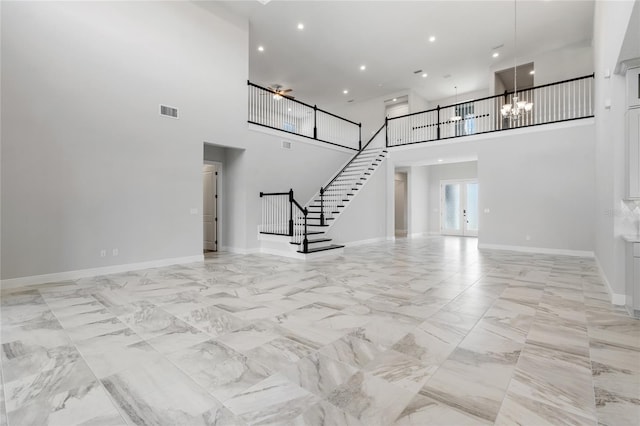 unfurnished living room featuring a high ceiling