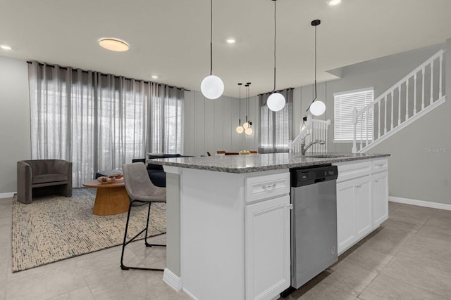 kitchen with white cabinetry, dishwasher, a kitchen island with sink, and hanging light fixtures