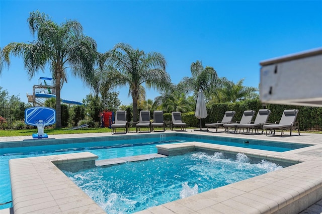 view of swimming pool with an in ground hot tub