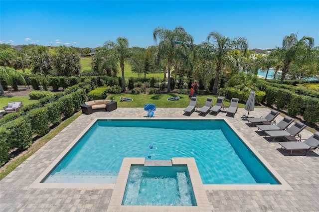 view of pool with an in ground hot tub, a patio area, and a lawn