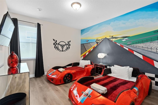 bedroom featuring a textured ceiling and light hardwood / wood-style floors