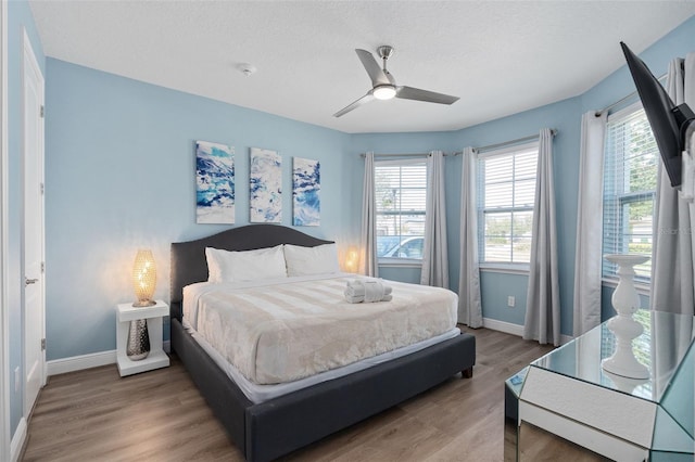 bedroom featuring hardwood / wood-style flooring, ceiling fan, and a textured ceiling