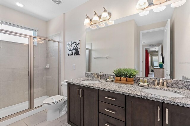 bathroom with tile patterned flooring, a notable chandelier, toilet, a shower with door, and vanity