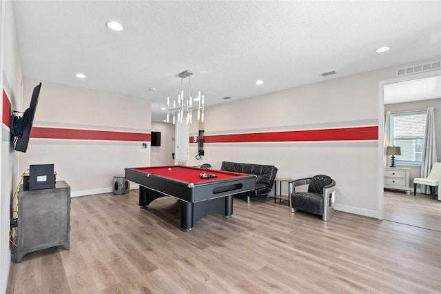 playroom with light hardwood / wood-style flooring, a chandelier, a textured ceiling, and pool table