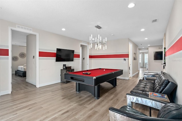 playroom featuring hardwood / wood-style floors, a textured ceiling, an inviting chandelier, and pool table