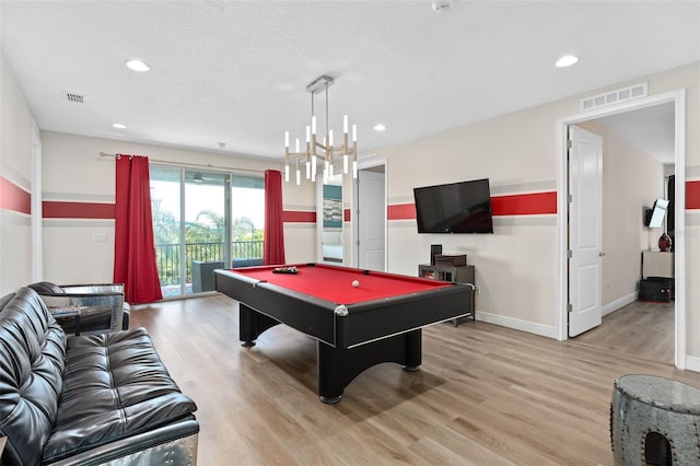 game room featuring light wood-type flooring, a textured ceiling, and pool table