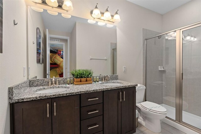 bathroom with tile patterned flooring, vanity, a shower with door, and toilet