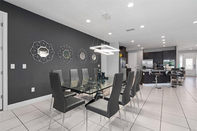 dining room with light tile patterned flooring and a textured ceiling