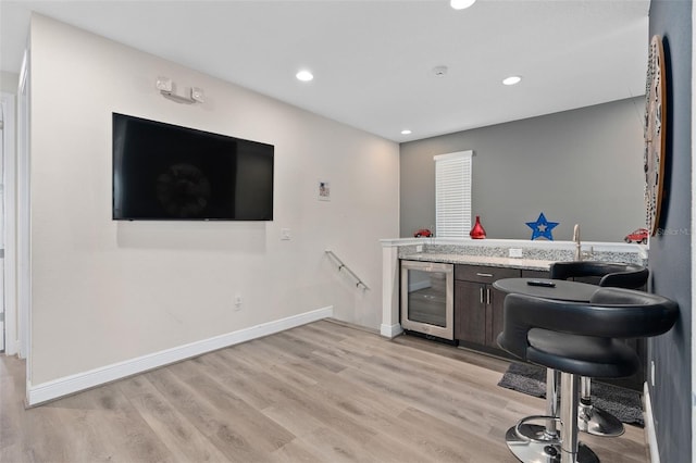 bar featuring wine cooler and light hardwood / wood-style flooring