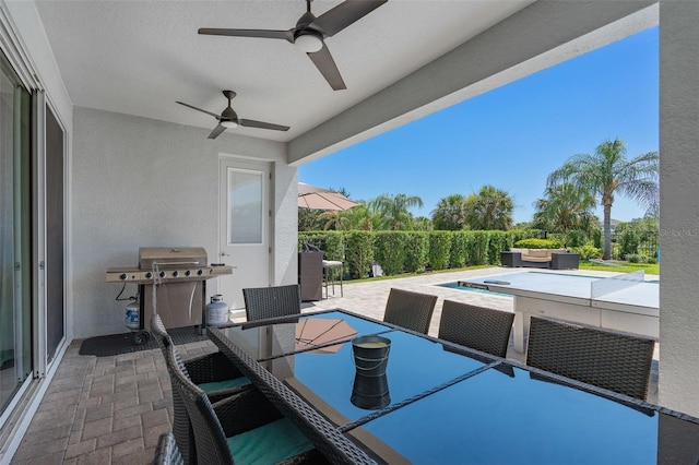 view of patio / terrace with area for grilling, ceiling fan, and an outdoor bar