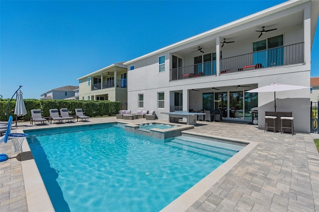 view of swimming pool featuring an in ground hot tub, a bar, a patio, and an outdoor hangout area