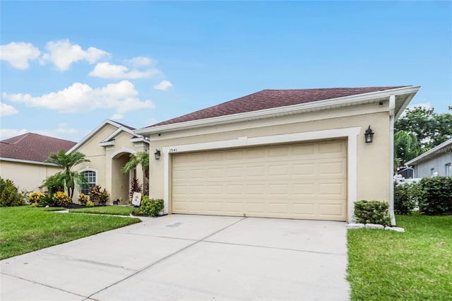 single story home with a garage, concrete driveway, a front lawn, and stucco siding