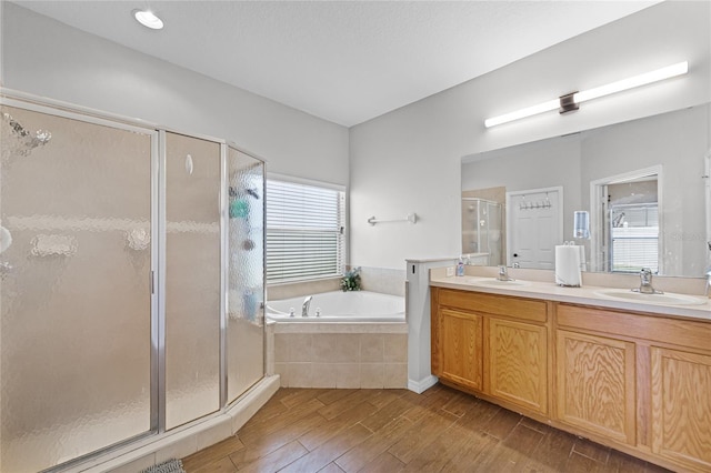 full bathroom with a garden tub, wood finished floors, a stall shower, and a sink