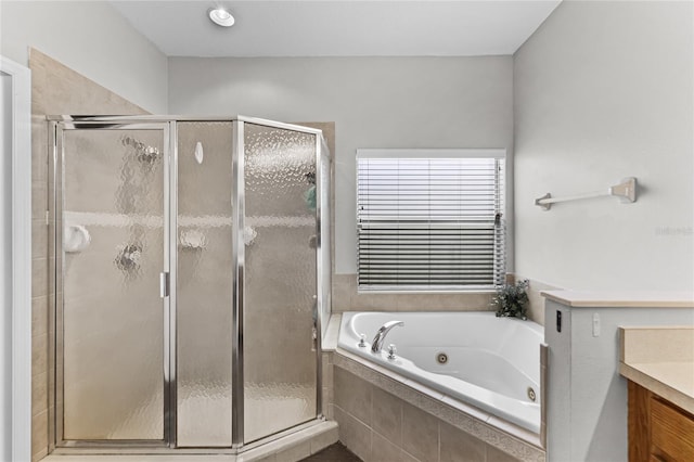 bathroom featuring a tub with jets, a shower stall, and vanity