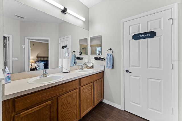 bathroom featuring a sink, wood finished floors, ensuite bath, and visible vents