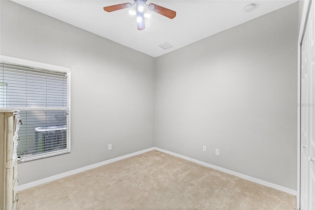 unfurnished room featuring light colored carpet, ceiling fan, and baseboards