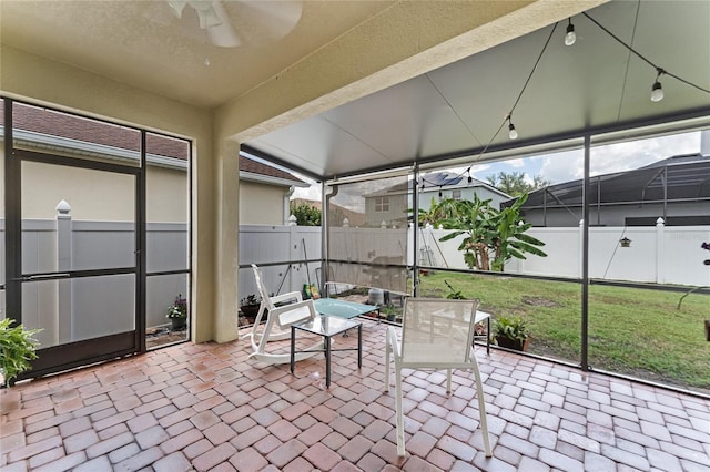 unfurnished sunroom featuring a ceiling fan