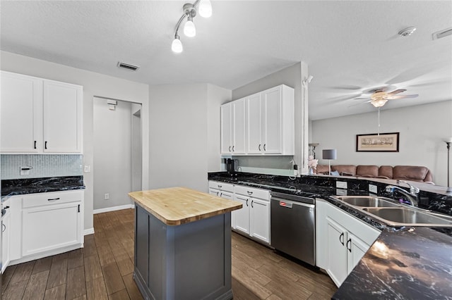 kitchen featuring dishwasher, wooden counters, visible vents, and white cabinetry