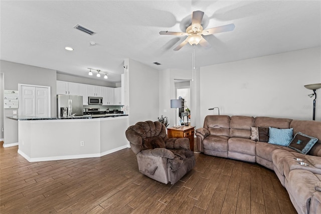 living room featuring a ceiling fan, baseboards, visible vents, and dark wood-type flooring