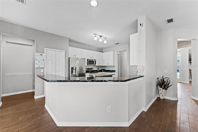 kitchen featuring appliances with stainless steel finishes, dark wood-type flooring, visible vents, and white cabinets