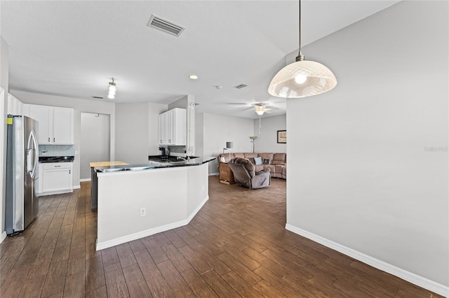 kitchen featuring visible vents, white cabinetry, open floor plan, stainless steel fridge with ice dispenser, and dark countertops