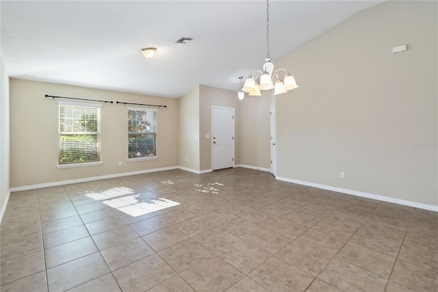 empty room with light tile patterned floors, a chandelier, and lofted ceiling