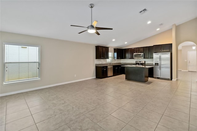 kitchen featuring appliances with stainless steel finishes, light tile patterned floors, a kitchen island, and dark brown cabinetry