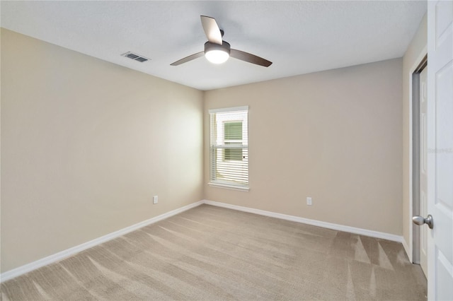 empty room with ceiling fan and light colored carpet