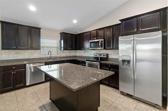 kitchen with sink, stainless steel appliances, lofted ceiling, dark brown cabinets, and a kitchen island