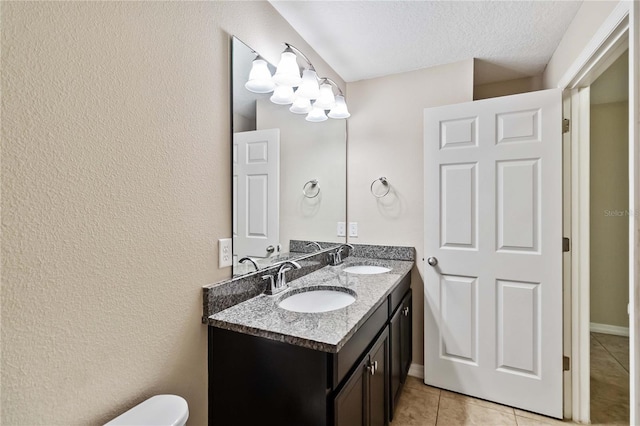 bathroom featuring tile patterned flooring, vanity, and a textured ceiling