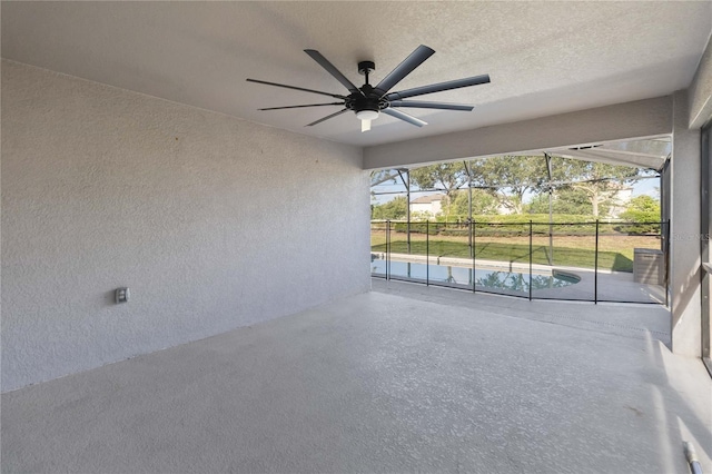 unfurnished sunroom featuring ceiling fan