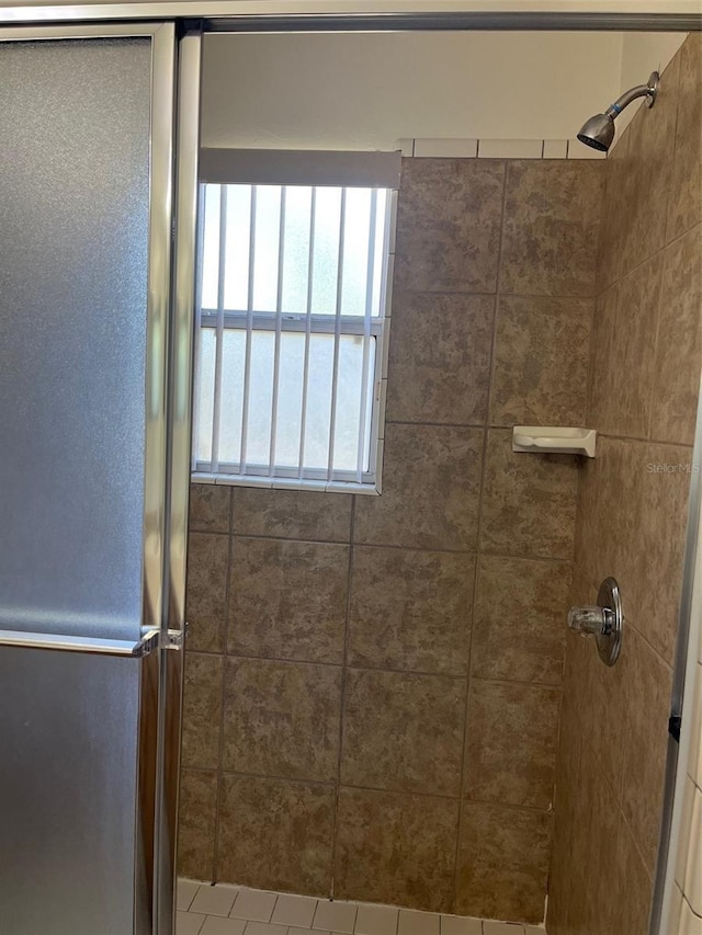 bathroom featuring a tile shower and a wealth of natural light