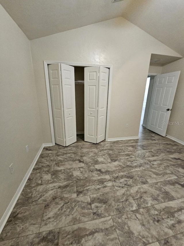 unfurnished bedroom featuring a closet and vaulted ceiling