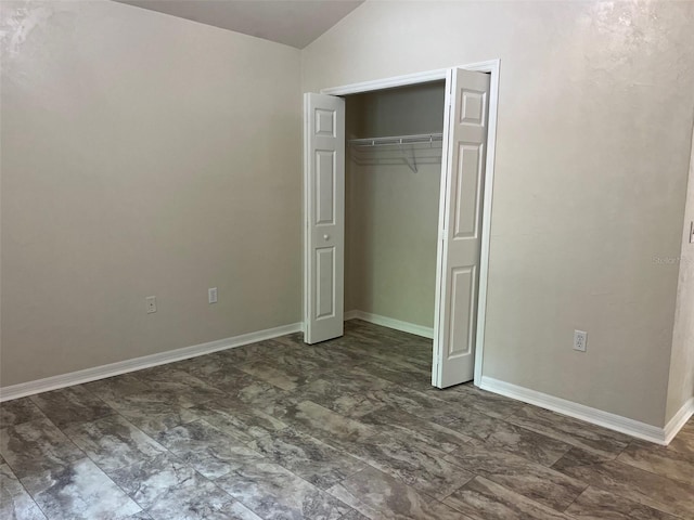 unfurnished bedroom with a closet and vaulted ceiling