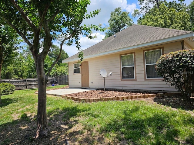 rear view of house with a lawn and a patio