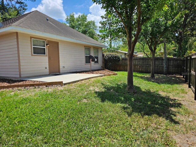 back of house with a patio area and a yard