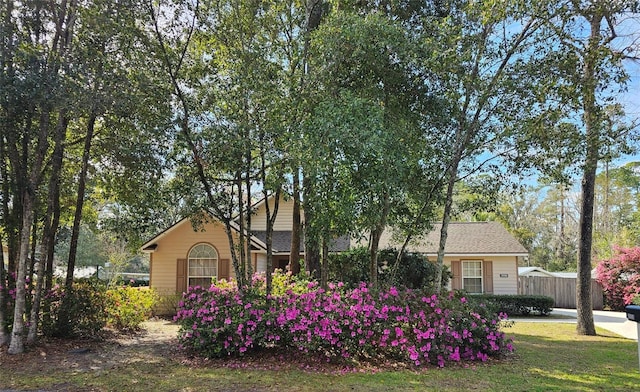 view of front facade featuring a front yard and fence